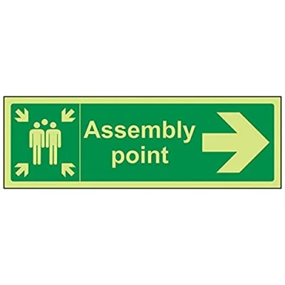 Image of VSafety 17034AX G &quot;Fire Assembly Point Arrow Right&quot; Sign, Glow In Dark, 1 mm Plastic, Landscape, 300 x 100 mm, Green