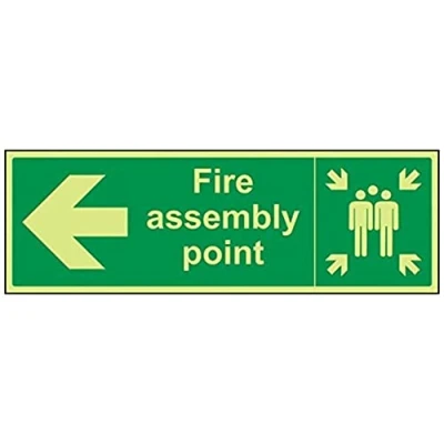 Image of VSafety 17021BJ G &quot;Fire Assembly Point Arrow Left&quot; Sign, Glow In Dark, 1 mm Plastic, Landscape, 450 x 150 mm, Green