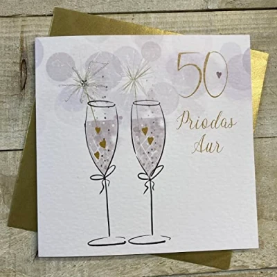 Image of WHITE COTTON CARDS 50 PRIODAS AUR (GOLDEN WEDDING ANNIVERSARY) FLUTES WITH SPARKLER WELSH ANNIVERSARY CARD, HANDFINISHED (W DA50)